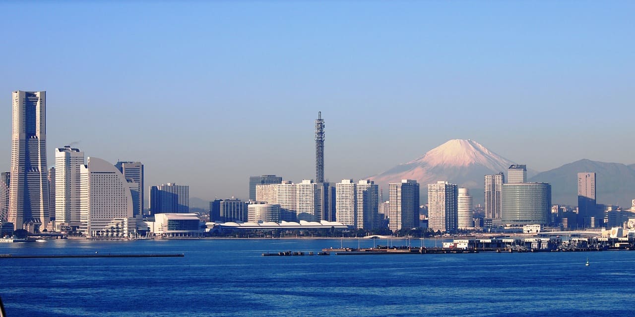 Die Skyline von Yokohama mit bleuem Meer, dahinter der heilige Berg Fuji